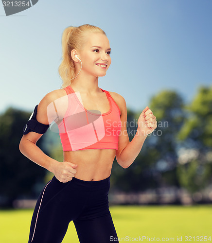 Image of sporty woman running with smartphone and earphones