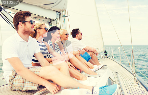 Image of smiling friends sitting on yacht deck