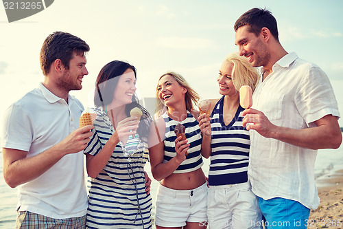 Image of friends eating ice cream and talking on beach