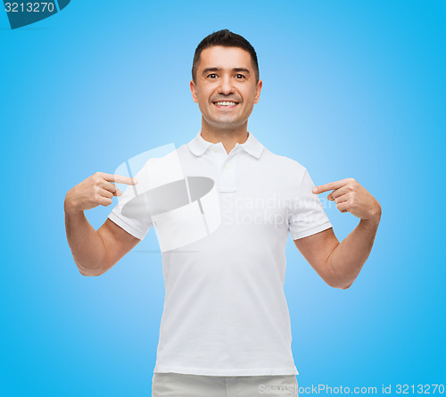 Image of smiling man in t-shirt pointing fingers on himself