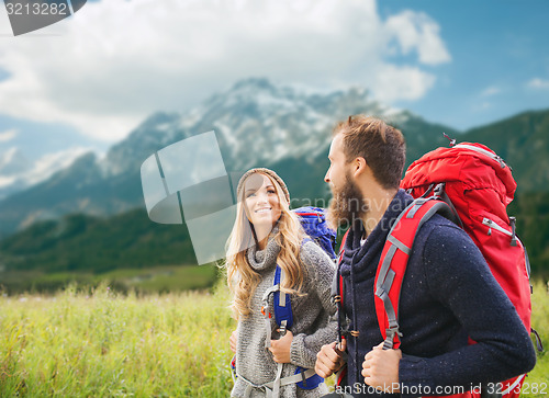 Image of smiling couple with backpacks hiking