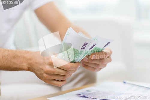 Image of close up of man hands counting money at home