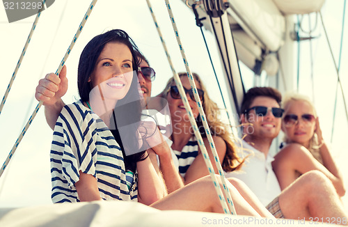 Image of smiling friends sitting on yacht deck