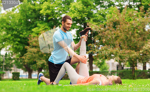 Image of smiling couple stretching outdoors