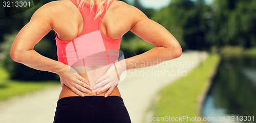 Image of close up of sporty woman touching her back