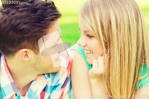 Image of smiling couple looking at each other in park