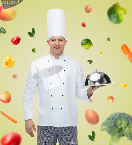 Image of happy male chef cook holding cloche