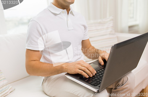 Image of close up of man working with laptop at home