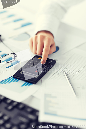 Image of woman hand with calculator and papers