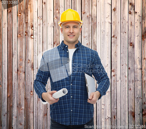 Image of smiling male builder in helmet with blueprint