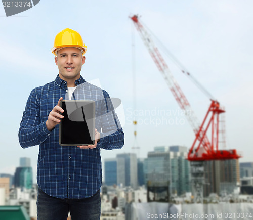 Image of smiling male builder in helmet with tablet pc
