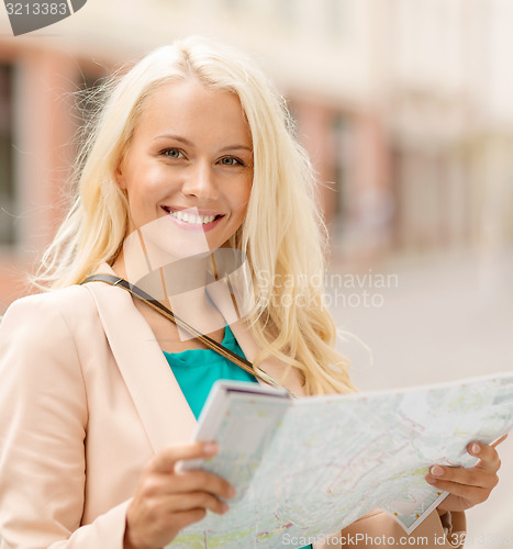 Image of beautiful woman with map in the city
