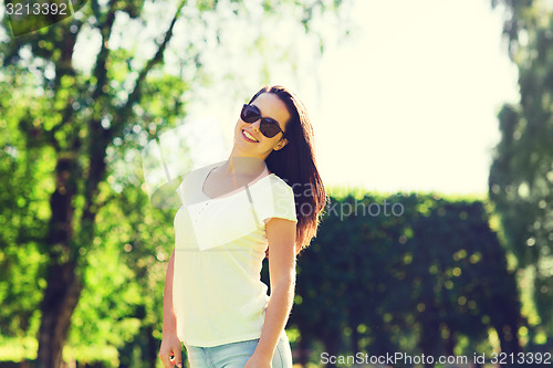Image of smiling young woman with sunglasses in park