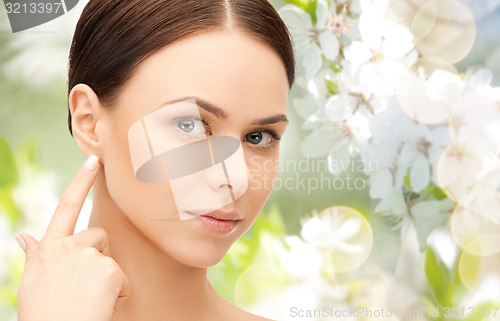 Image of face of beautiful woman touching her ear