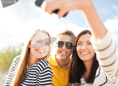 Image of group of friends taking selfie with cell phone