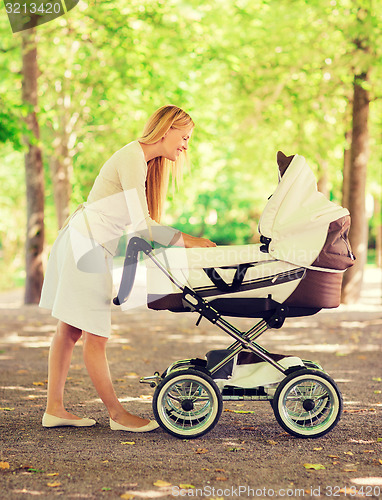 Image of happy mother with stroller in park