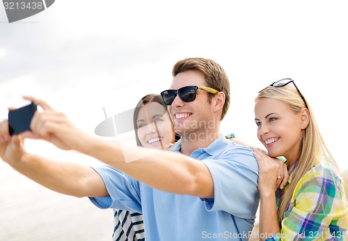 Image of group of friends taking selfie with cell phone