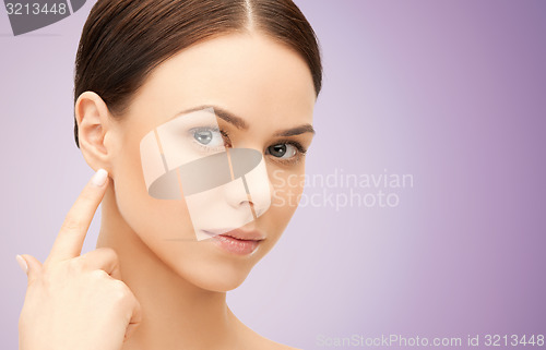 Image of face of beautiful woman touching her ear