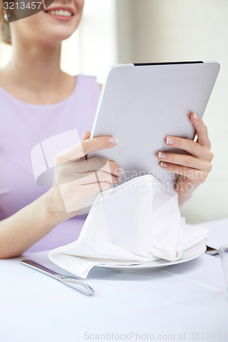 Image of close up of woman with tablet pc at resturant