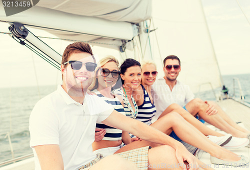 Image of smiling friends sitting on yacht deck