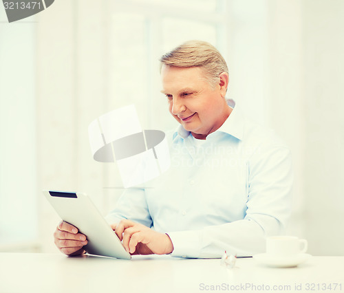 Image of old man with tablet pc computer at home