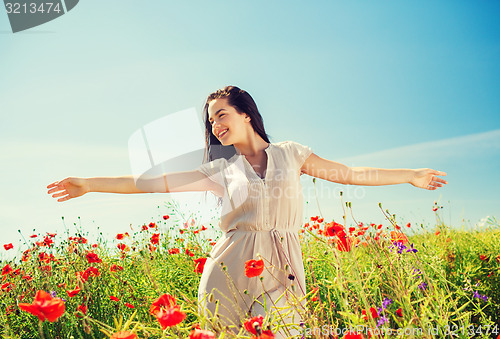 Image of smiling young woman on poppy field