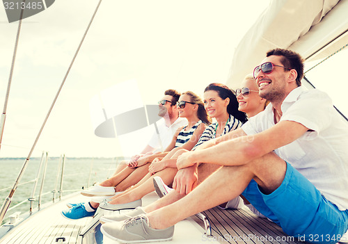 Image of smiling friends sitting on yacht deck