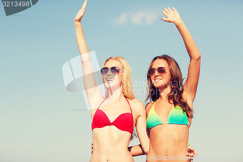 Image of two smiling young women on beach