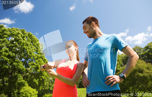 Image of smiling people with heart rate watches outdoors