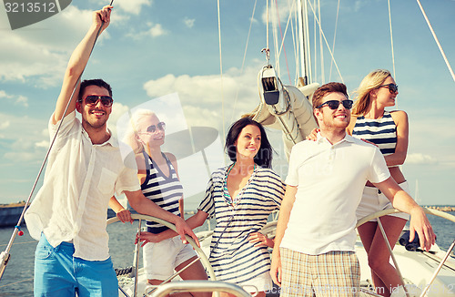 Image of smiling friends sailing on yacht