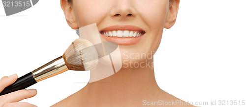 Image of woman applying powder foundation with brush