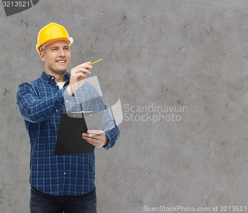 Image of smiling male builder in helmet with clipboard