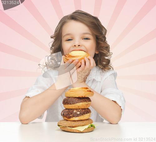 Image of happy little girl eating junk food
