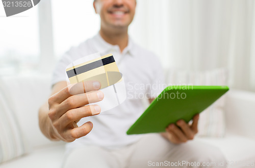 Image of close up of man with credit card and tablet pc