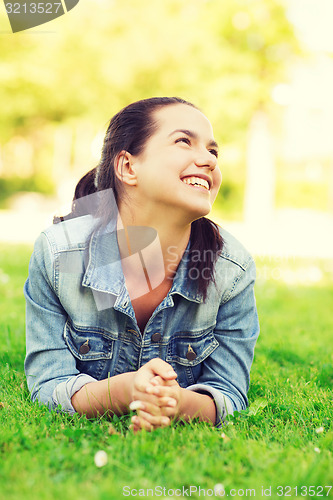 Image of smiling young girl lying on grass