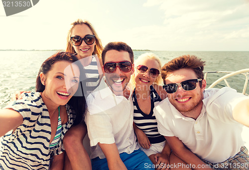 Image of smiling friends sitting on yacht deck