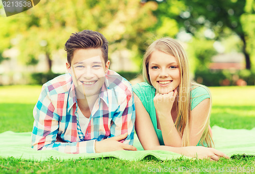 Image of smiling couple lying on blanket in park