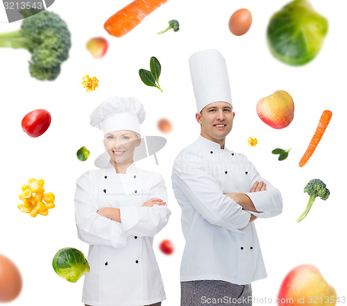 Image of happy chef couple or cooks over food background