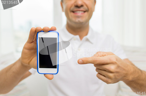 Image of close up of happy man with smartphone at home