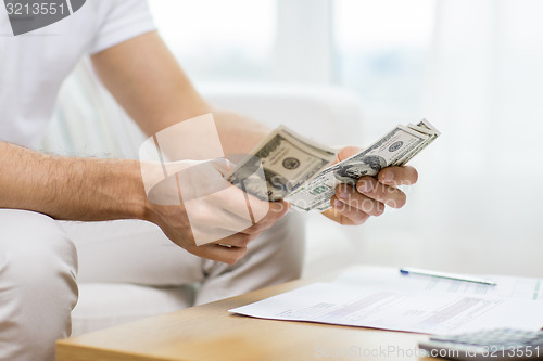 Image of close up of man hands counting money at home