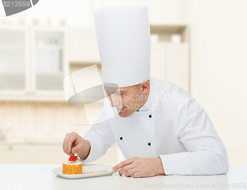 Image of happy male chef cook decorating dessert