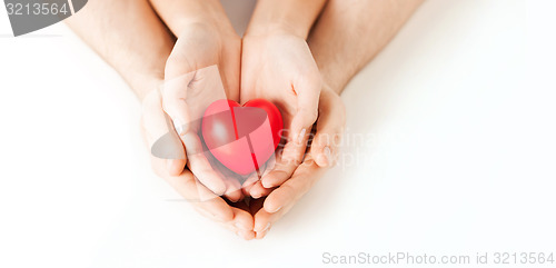 Image of couple hands holding red heart