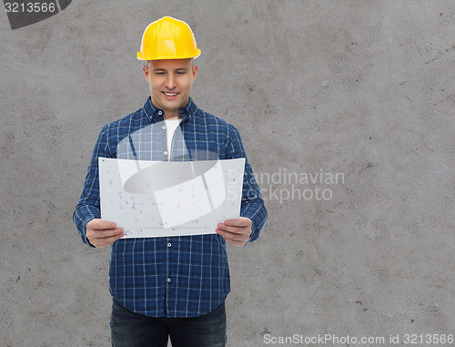 Image of smiling male builder in helmet with blueprint