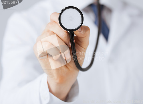 Image of doctor hand with stethoscope listening something