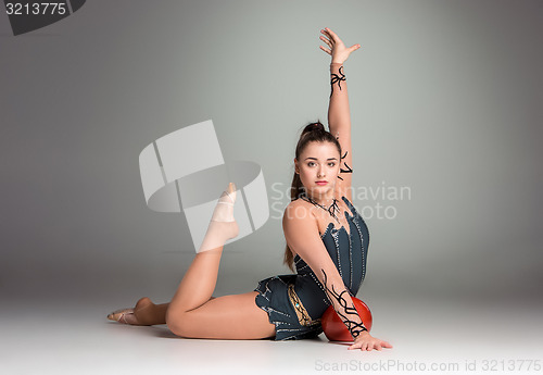 Image of teenager doing gymnastics exercises with red gymnastic ball