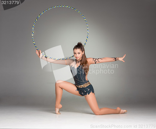 Image of teenager doing gymnastics exercises with colorful hoop