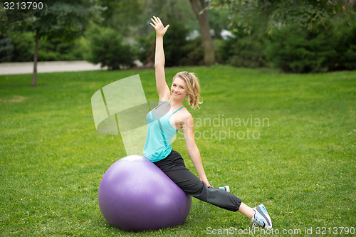Image of Young happy woman with fitness ball, outdoor