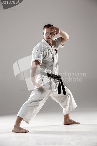 Image of Man in white kimono training karate