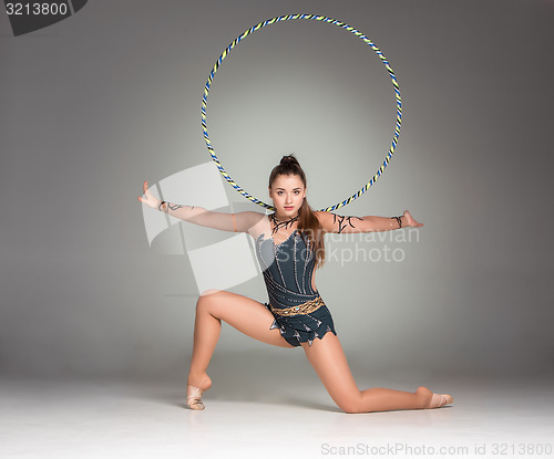 Image of teenager doing gymnastics exercises with colorful hoop