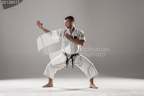 Image of Man in white kimono training karate